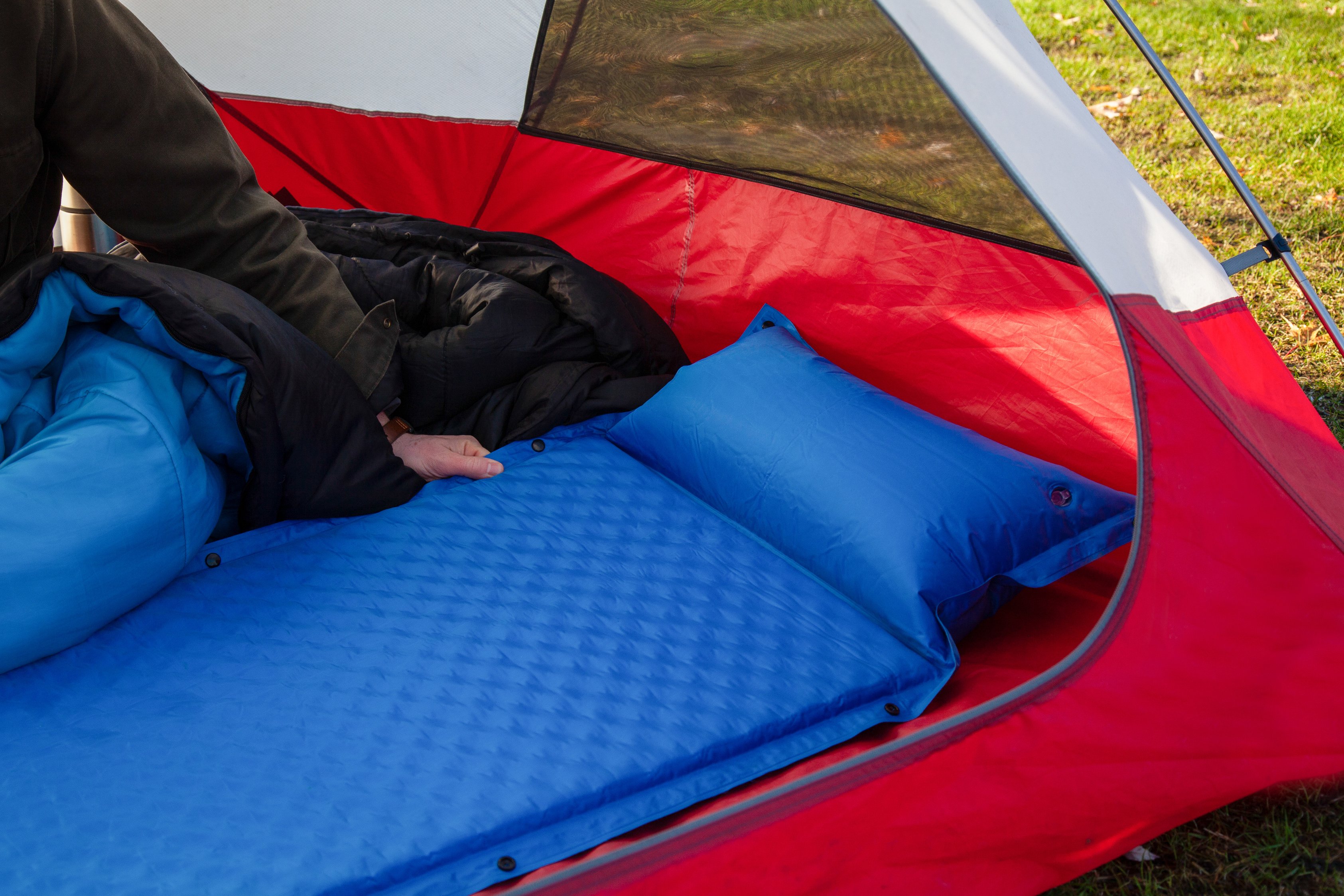 A close up of a blue camping inflating mattress pad