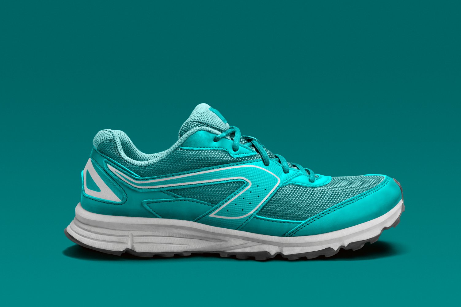 Side view of single turquoise running shoe